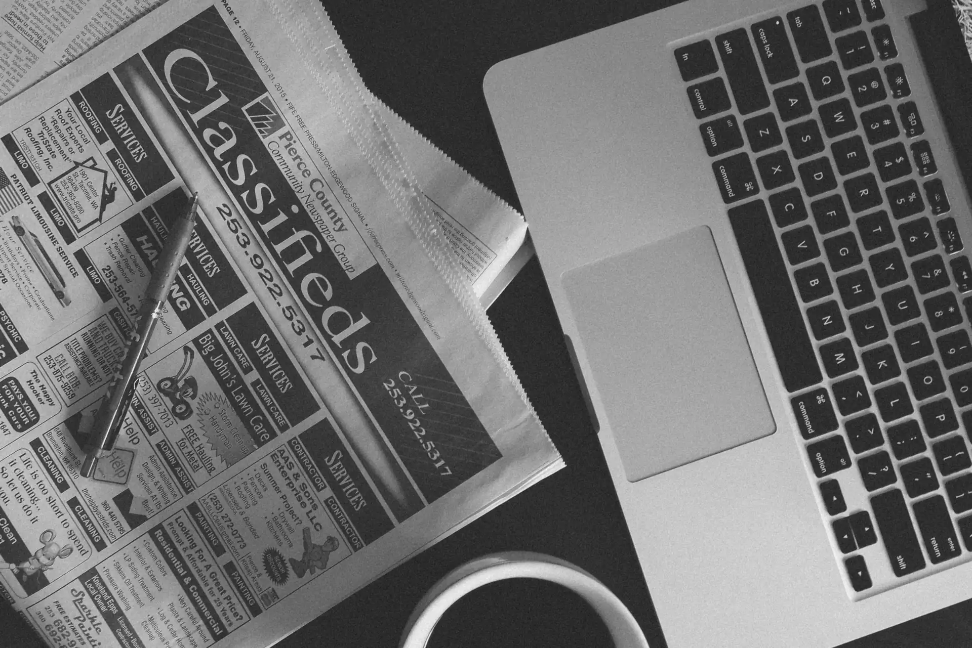 Una computadora y un periódico simbolizan el contenido SEO y anuncios publicitarios